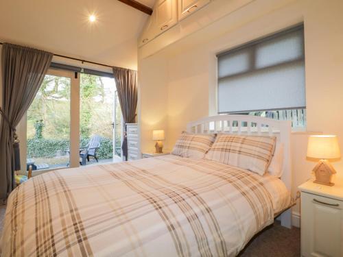 1 dormitorio con cama y ventana grande en Carwinley Mill House Cottage, en Canonbie