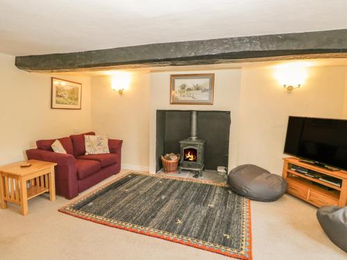a living room with a couch and a fireplace at Town End Farmhouse in Newby Bridge