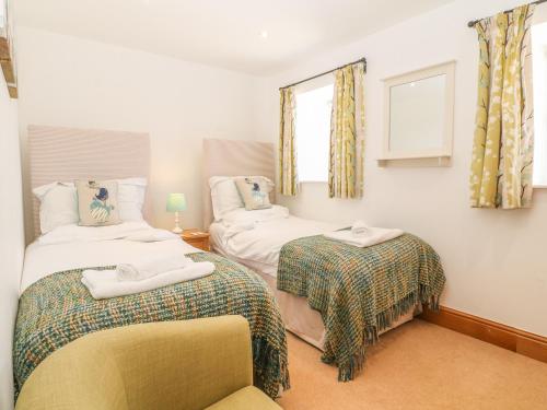 1 dormitorio con 2 camas y ventana en Cornel Glyd, en Dyffryn