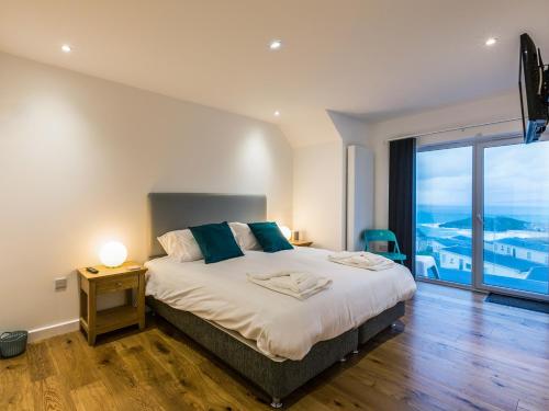 a bedroom with a large bed and a large window at Chy Lowen in St Ives
