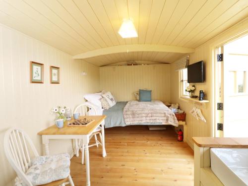 a small bedroom with a bed and a table at Willow in Wadebridge