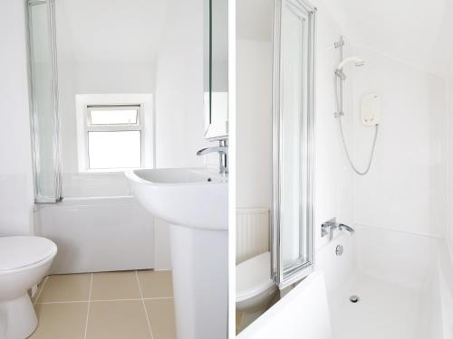 a white bathroom with a sink and a toilet at The Coach House in Trevilley