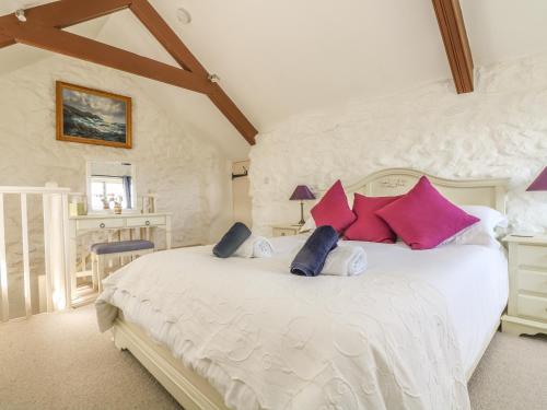 ペンザンスにあるBoar's Houseの大きな白いベッドと赤い枕のある寝室