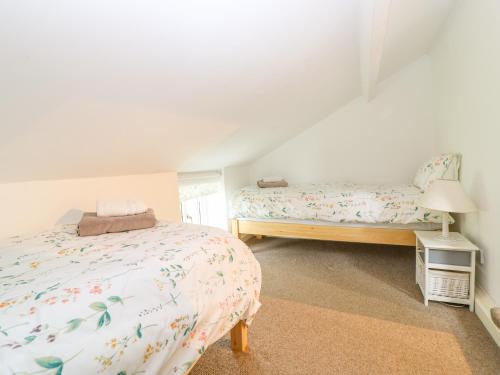 a bedroom with two beds and a window at Broom Cottage in East Rudham