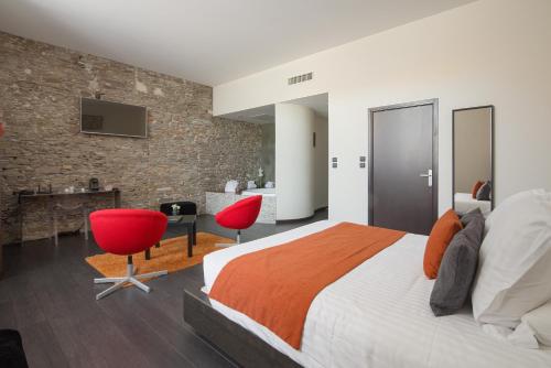 - une chambre avec un grand lit et des chaises rouges dans l'établissement Le Domaine des Lys, à Ancenis
