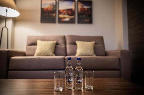 two bottles and glasses on a table with a couch at The Warwickshire Hotel and Country Club in Warwick