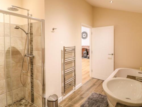 a bathroom with a shower and a sink at Hazel Cottage in Belper