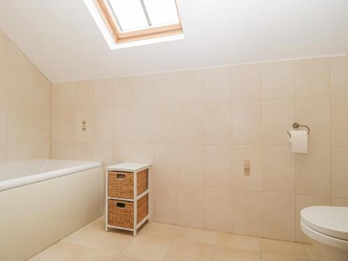 a bathroom with a toilet and a skylight at The Old Barn in Swanage