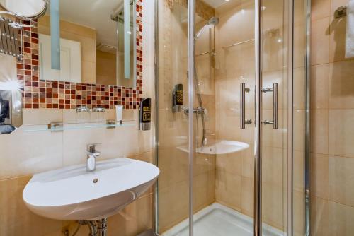 a bathroom with a sink and a shower at Hotel Astor in Munich