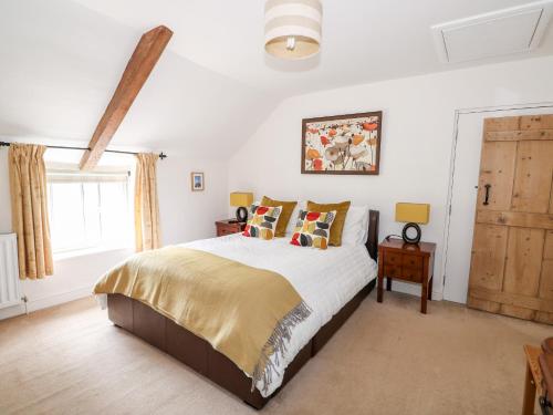 a bedroom with a large bed and a window at Flint Cottage in Swaffham