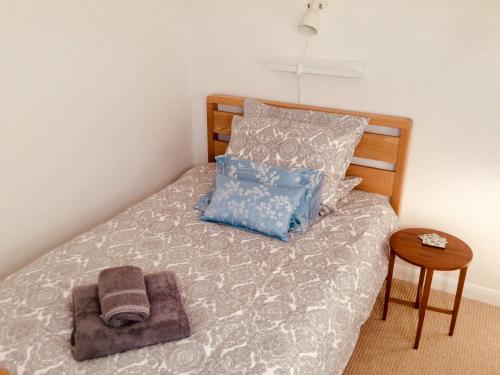 ein Bett mit einem Haufen Kissen und einem Handtuch darauf in der Unterkunft Kate's Cottage in Bourton on the Water