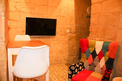 a room with a table and a chair and a tv at Malta's Naughtiest Cabaret in Il-Furjana