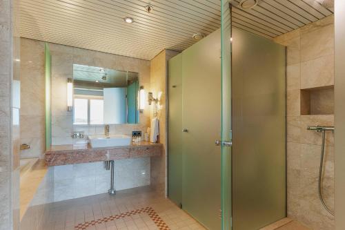 een badkamer met een douche en een wastafel bij Holiday Club Naantali Apartments in Naantali