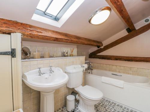 La salle de bains est pourvue de toilettes, d'un lavabo et d'une baignoire. dans l'établissement Swallow Cottage, à Scarborough