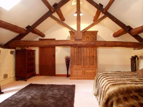 a bedroom with a bed and a wooden ceiling at The Loft in Dronfield