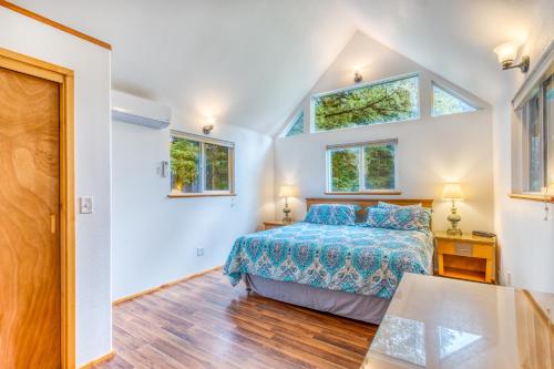 a bedroom with a bed and two windows at HATS House in Coos Bay