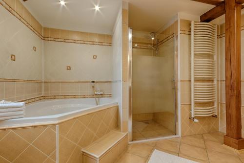 a bathroom with a tub and a shower at Romance Ubytování in Jindrichuv Hradec