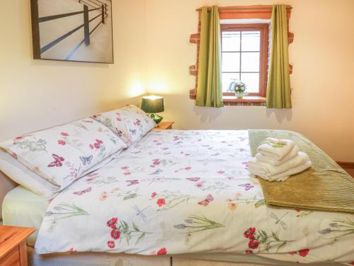 Un dormitorio con una cama con flores. en Lily Cottage, en Caernarfon