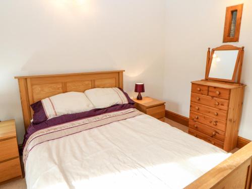um quarto com uma cama, uma cómoda e um espelho em The Stable em Brampton