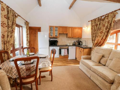 a kitchen and living room with a table and a couch at The Byre in Brampton