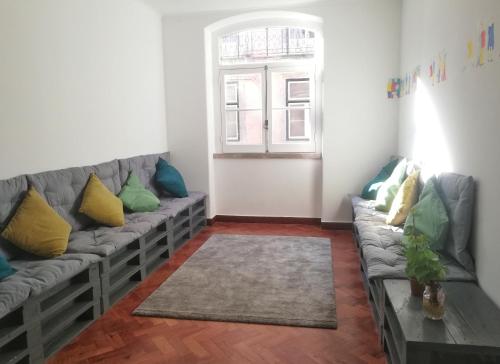 a living room with a couch and a window at Draft Hostel & Rooms in Lisbon