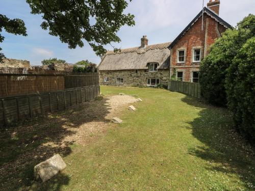 an old brick house with a yard in front of it at Hill Farm Cottage in Freshwater