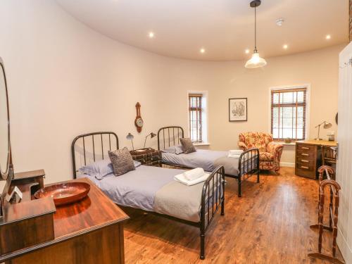 a bedroom with two beds and a desk and a sink at Hop House in Sittingbourne