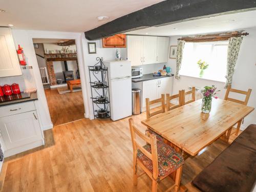 a kitchen and dining room with a wooden table at Hill Farm Cottage in Freshwater