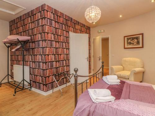 a bedroom with a bed and a large wall of books at Hop House in Sittingbourne