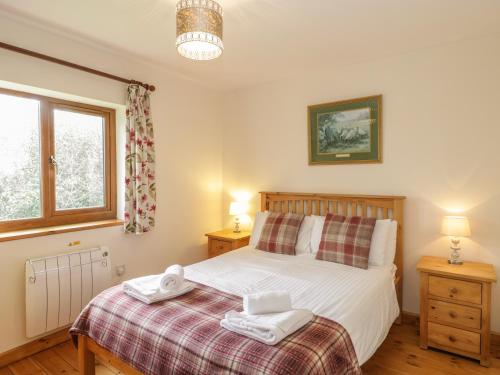 a bedroom with a bed with two towels on it at Ash Lodge in Watchet