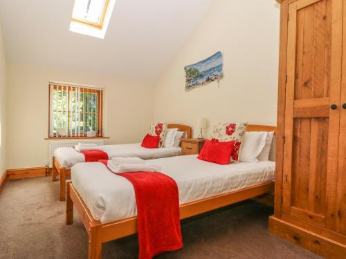 Dos camas en una habitación con mantas rojas. en The Granary en Thirsk