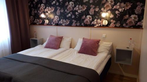 - une chambre avec un grand lit et 2 oreillers dans l'établissement Dinners, à Arboga
