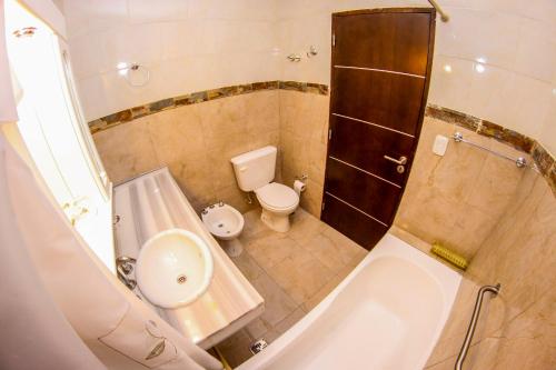La salle de bains est pourvue d'une baignoire, de toilettes et d'un lavabo. dans l'établissement Hotel Ciudad del Sol, à Termas de Río Hondo