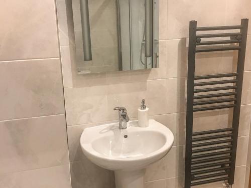 a bathroom with a sink and a mirror at Mews Cottage in Penrith