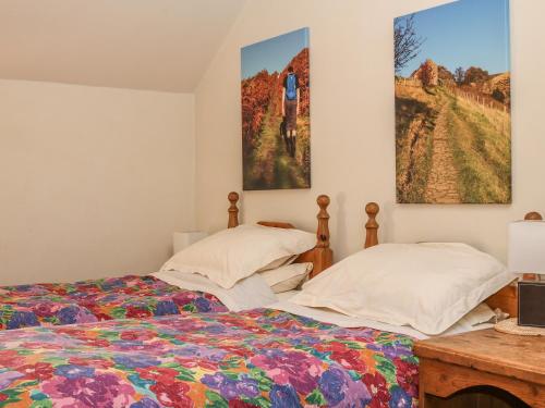 um quarto com duas camas e pinturas na parede em The Dairy em Buxton