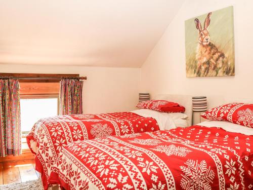 バクストンにあるThe Parlourの赤と白の毛布が備わる客室内のベッド2台
