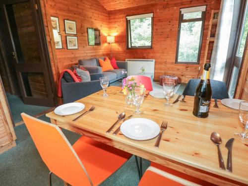 a wooden table with chairs and a bottle of wine at Buttermere in Ulverston