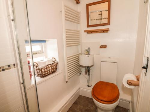 a bathroom with a toilet with a wooden toilet seat at The Studio in Bradwell