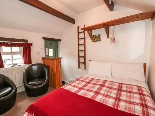 a bedroom with a bed and two chairs at The Studio in Bradwell