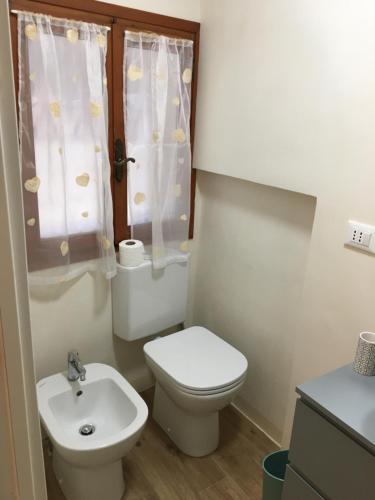 La petite salle de bains est pourvue de toilettes et d'un lavabo. dans l'établissement Casa Romana, à Venise