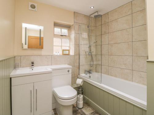 uma casa de banho com um WC, uma banheira e um lavatório. em Pear Tree Cottage em York