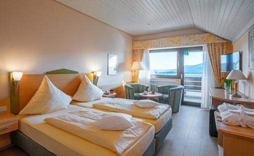 a hotel room with two beds and a balcony at Waldhotel Sonnenberg in Bollendorf
