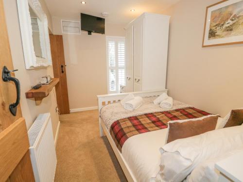 a small bedroom with a bed and a mirror at The Old Laundry in Ambleside