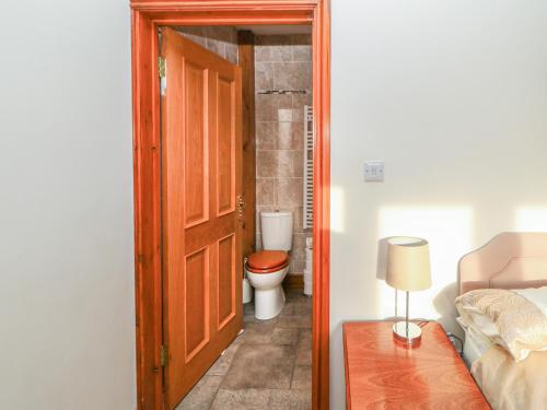 a bathroom with a toilet and a open door at Swallow Cottage in Brampton