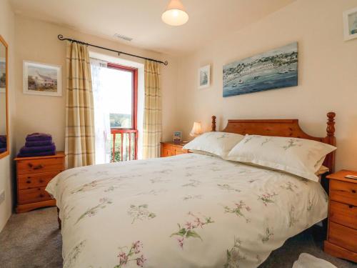 Un dormitorio con una cama grande y una ventana en Primrose Cottage, en Great Torrington
