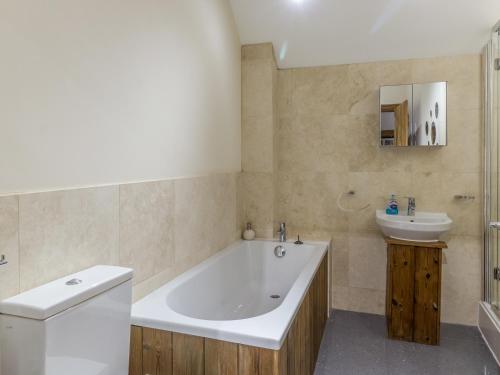 a bathroom with a tub and a toilet and a sink at Orchard Cottage in Durham