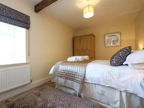 a bedroom with two beds and a window at Grove Cottage in Copley