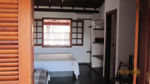 Habitación con cama y ventana en Chalés e suite Ilhabela, en Ilhabela