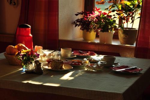 een tafel met borden met voedsel op een tafel met planten bij Bauernhof Mittereibenberger in Liebenau