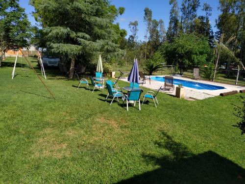 a group of chairs and umbrellas next to a swimming pool at Casas Cordoba in Villa Parque Siquiman